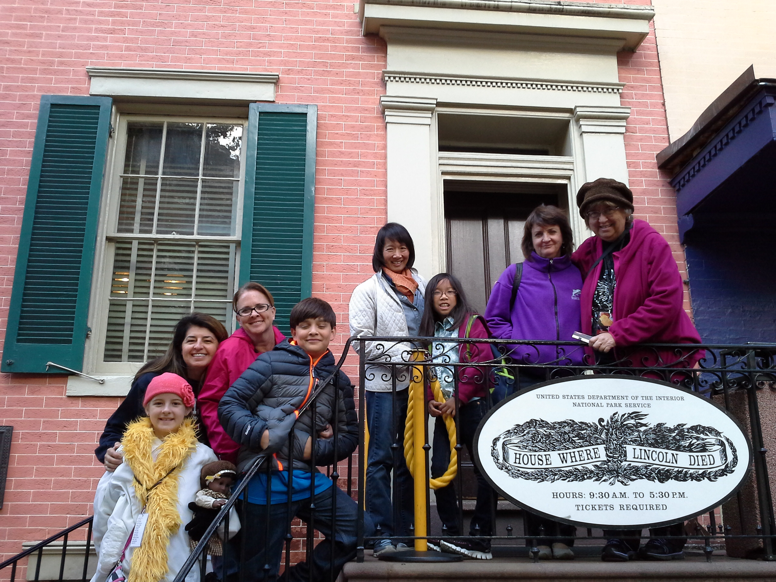 Adults and children standing on the steps of 14 Petersen House where Lincoln died