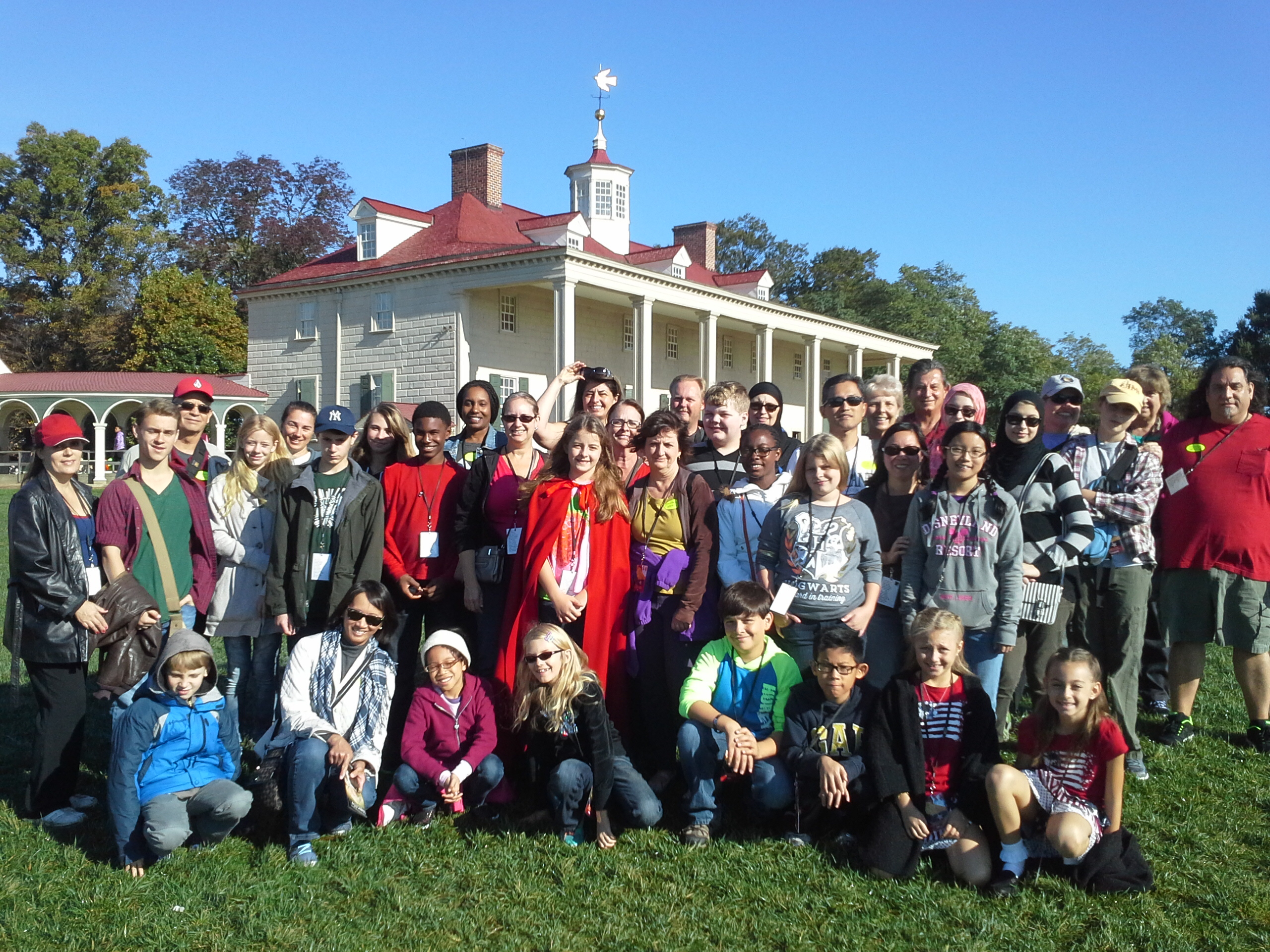 Middle school students posing for photo in front of historical Mt Vernon house