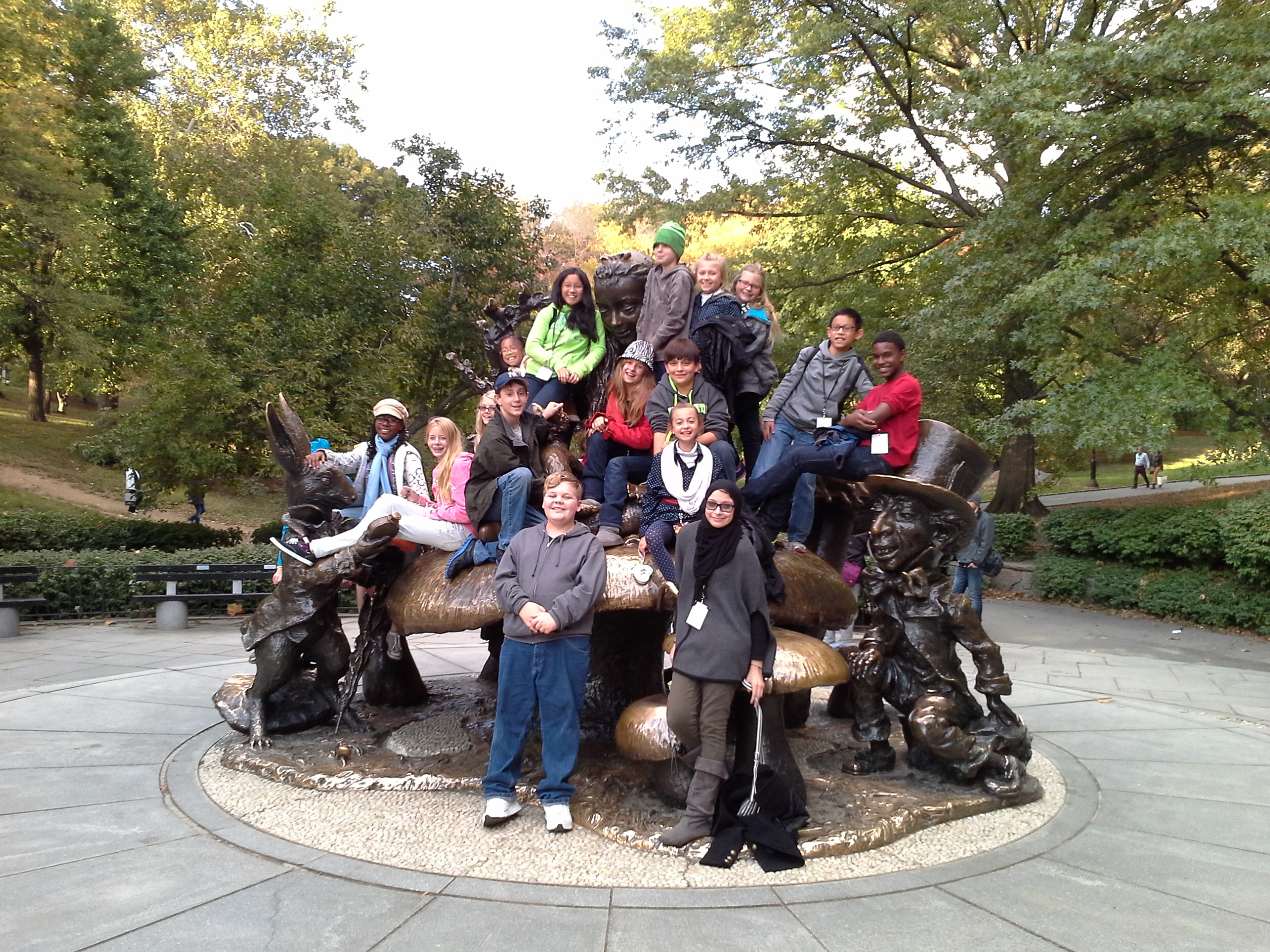 Group of middle school students posing on Alice in Wonderland statue in Central Park, New York City