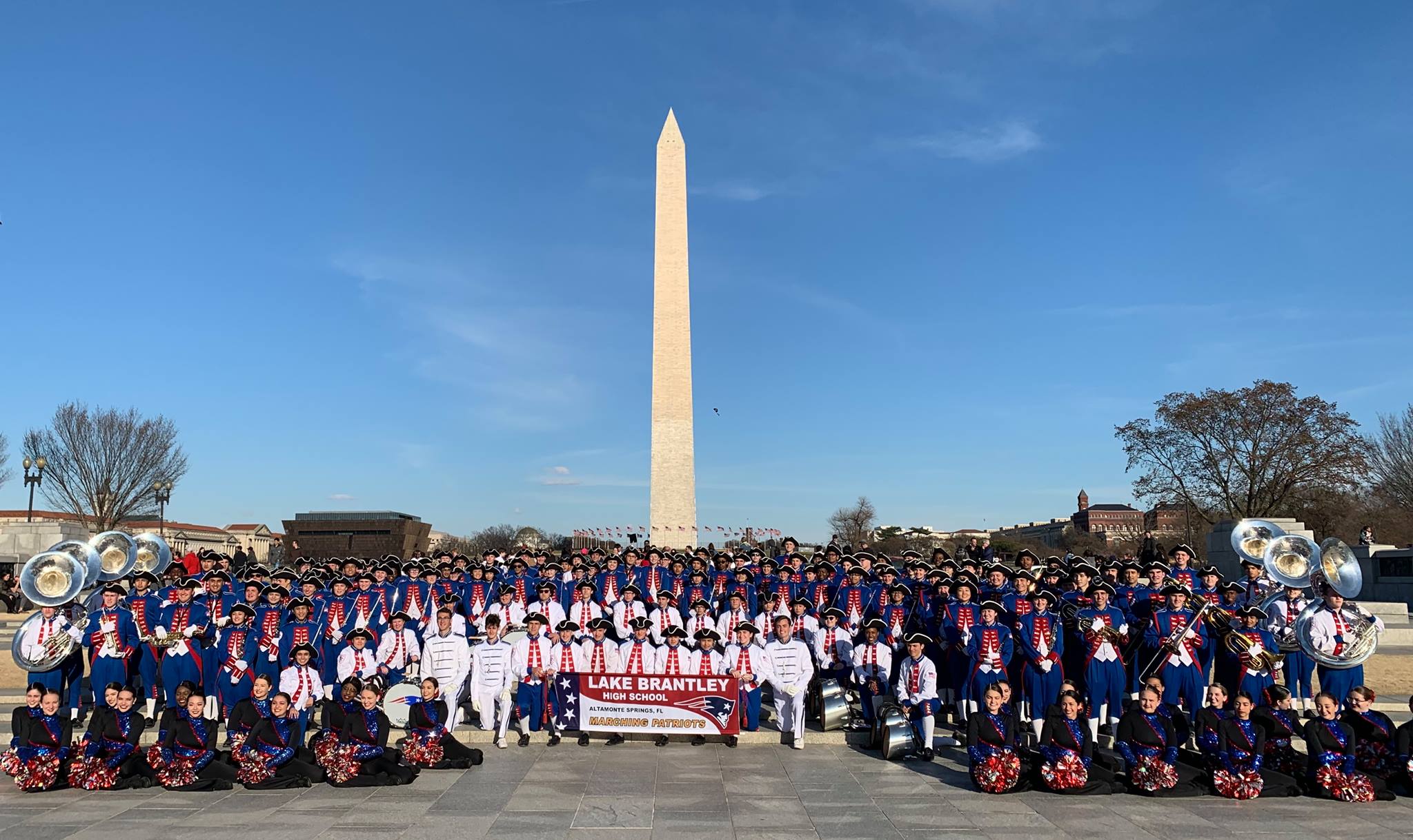 Student marching band posing in front of the Washington WWII Monument