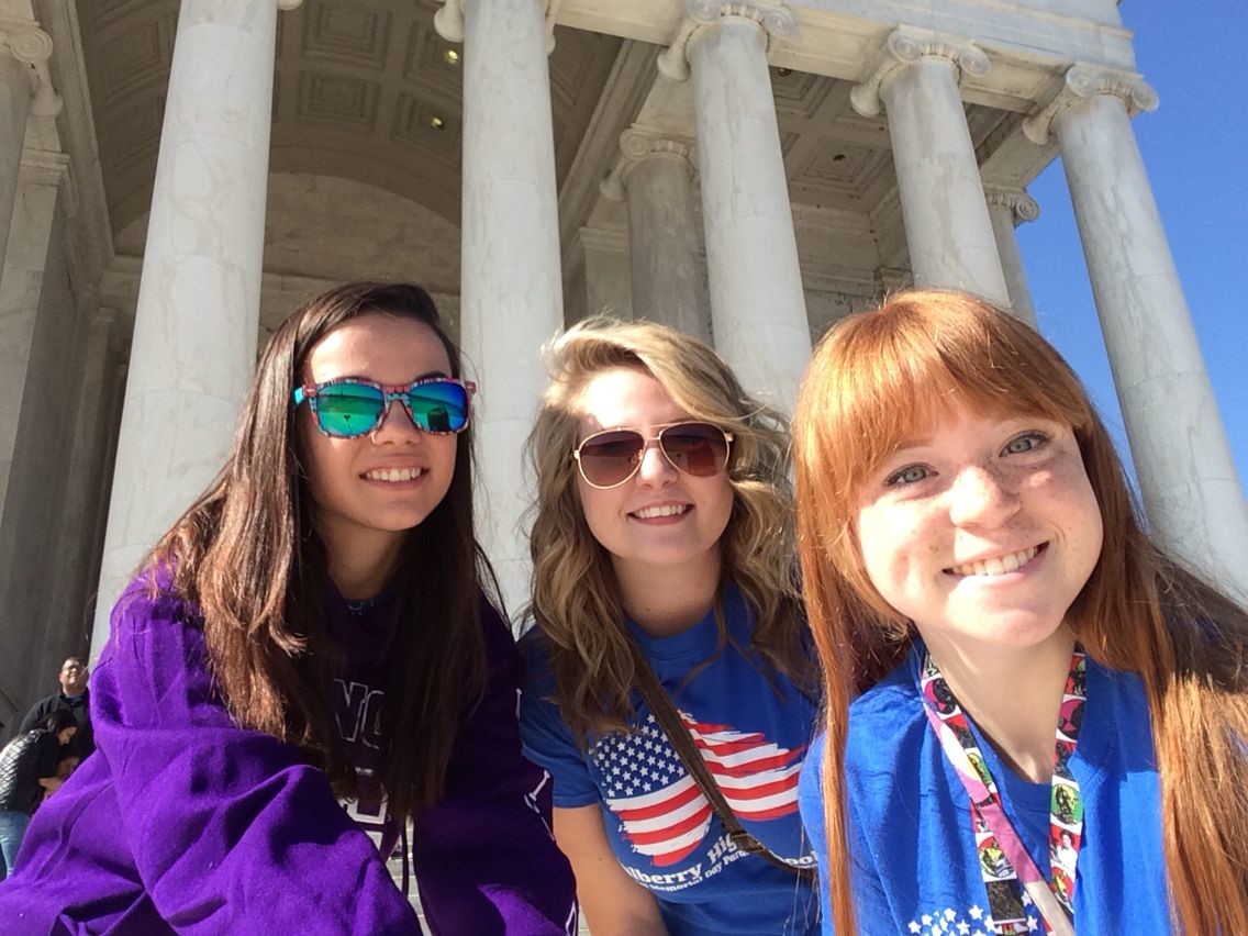 three teenage girls posing in front of Washington DC building