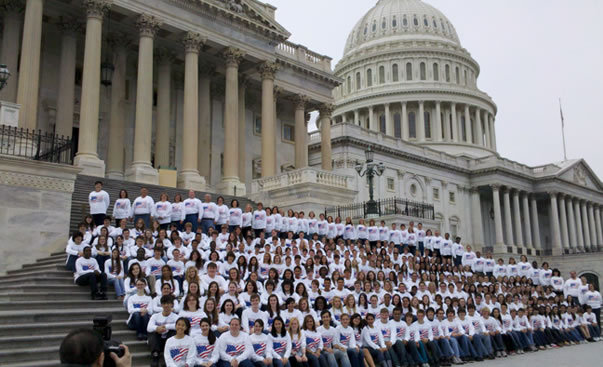 Group of students in white shirts posing on the steps of the Capitol Building in Washington DC